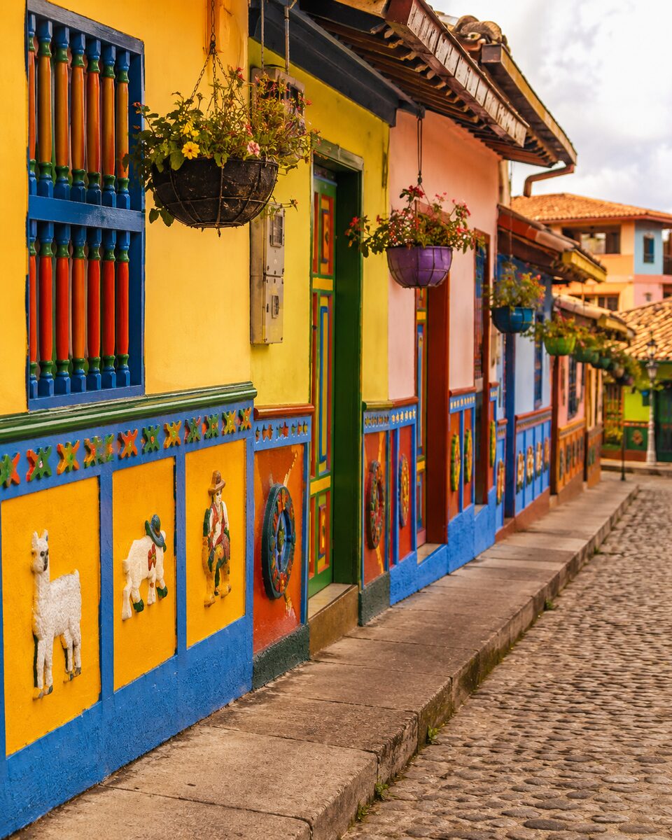 Colorful hand-painted zócalo facades on a cobblestone street in Guatapé, Colombia
